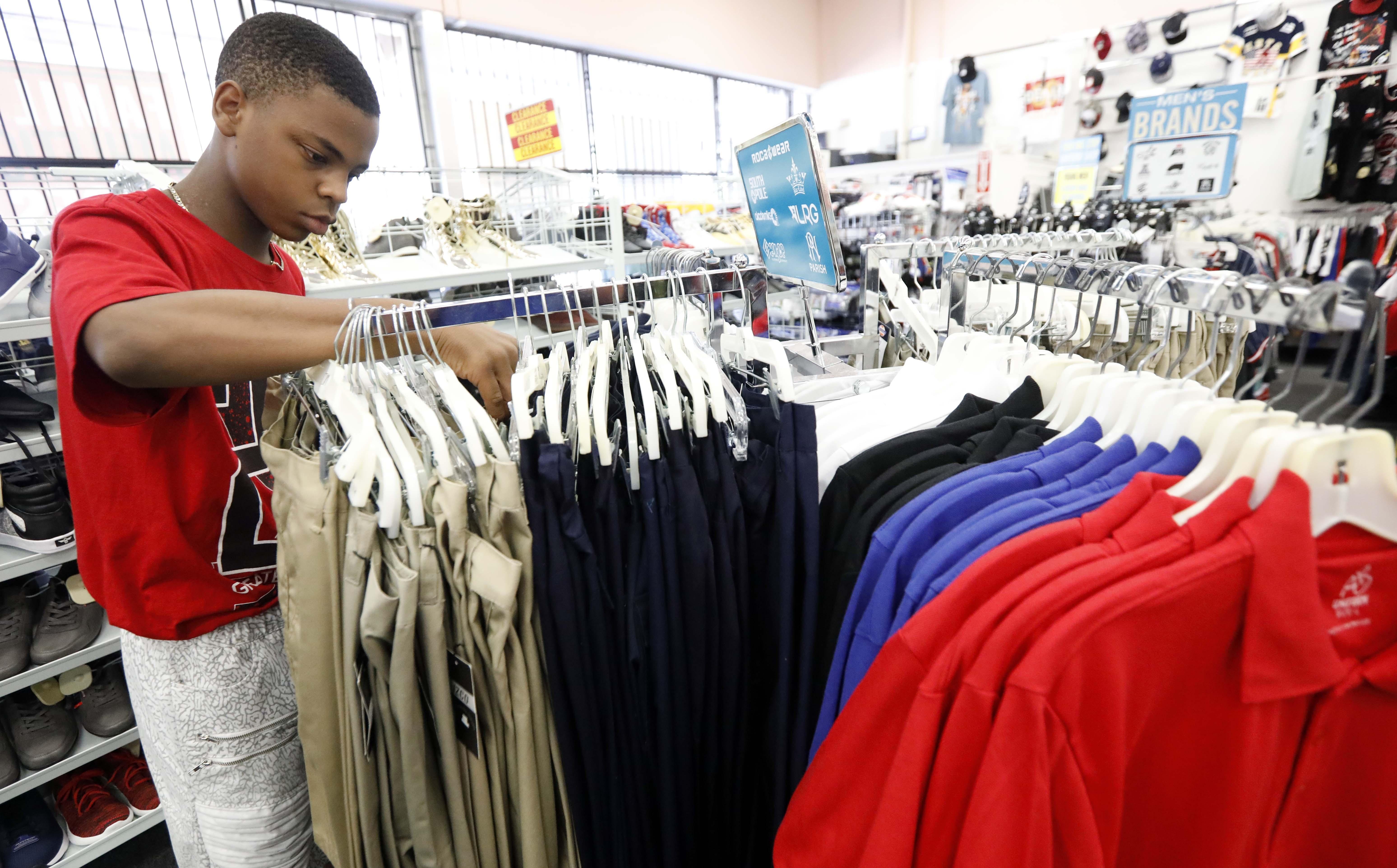 A teenage boy looks through slacks as part of a back to school tax free weekend.