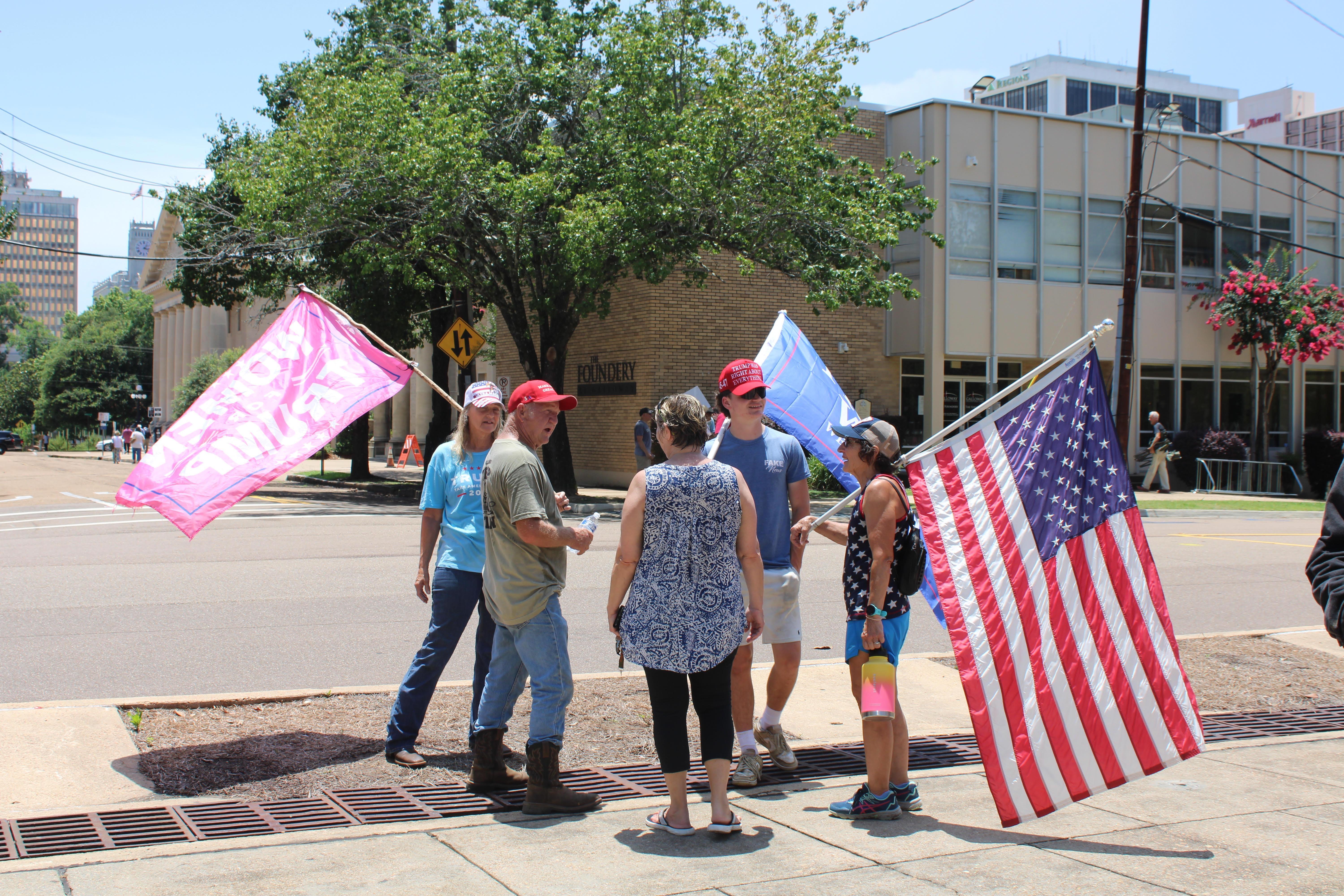 People holding pro-Trump flags and an American flag.