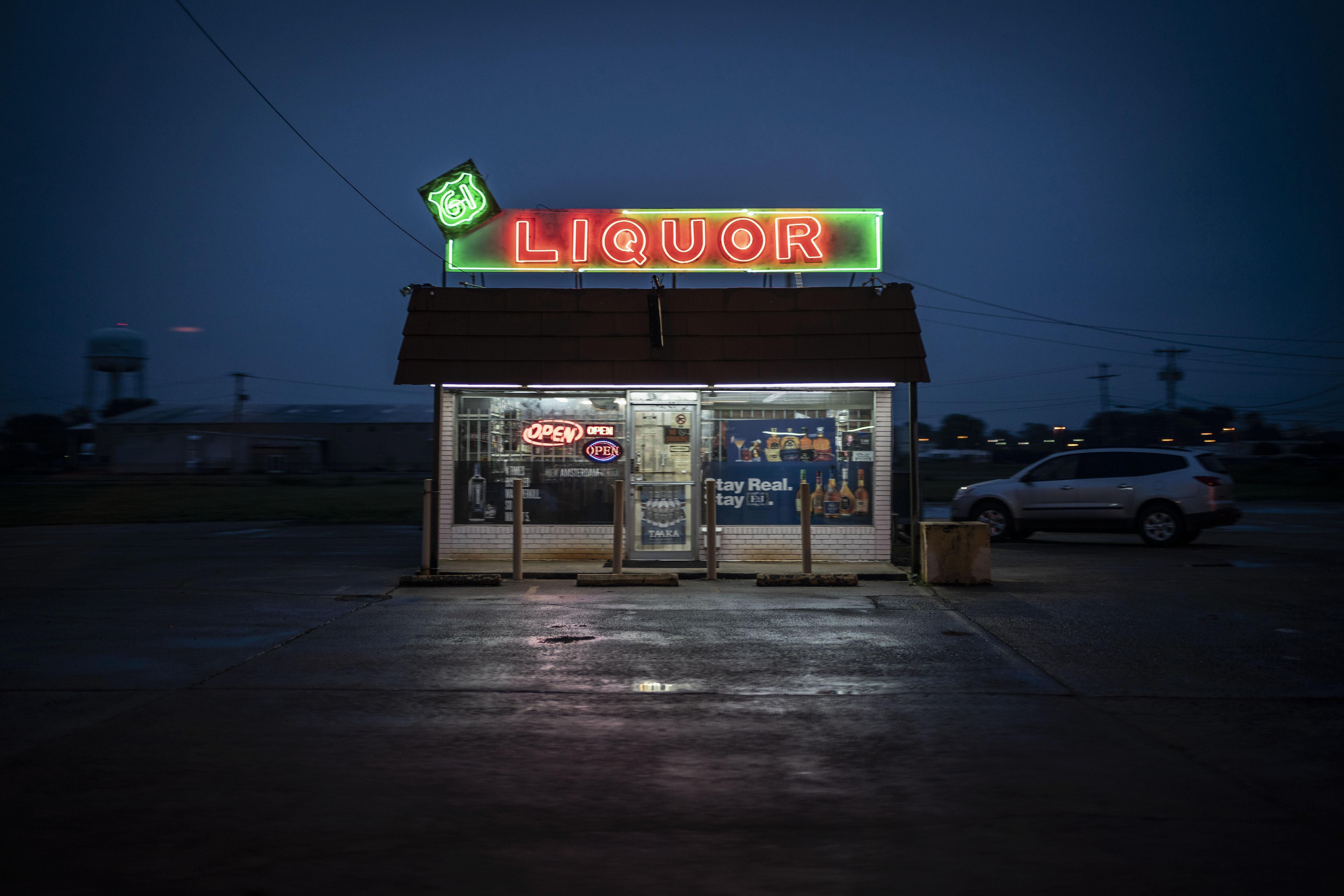 A liquor store is illuminated against the dusk sky in Cleveland, Mississippi.