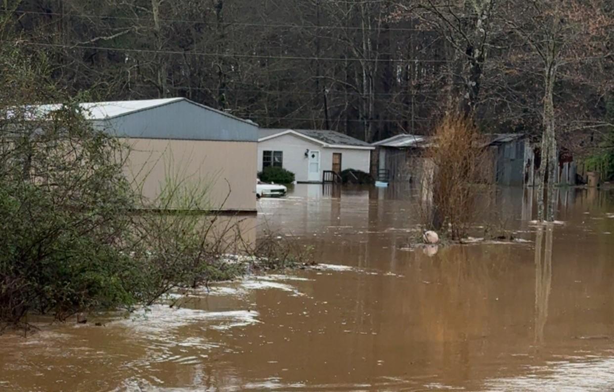 Homes are partially submerged in murky water.