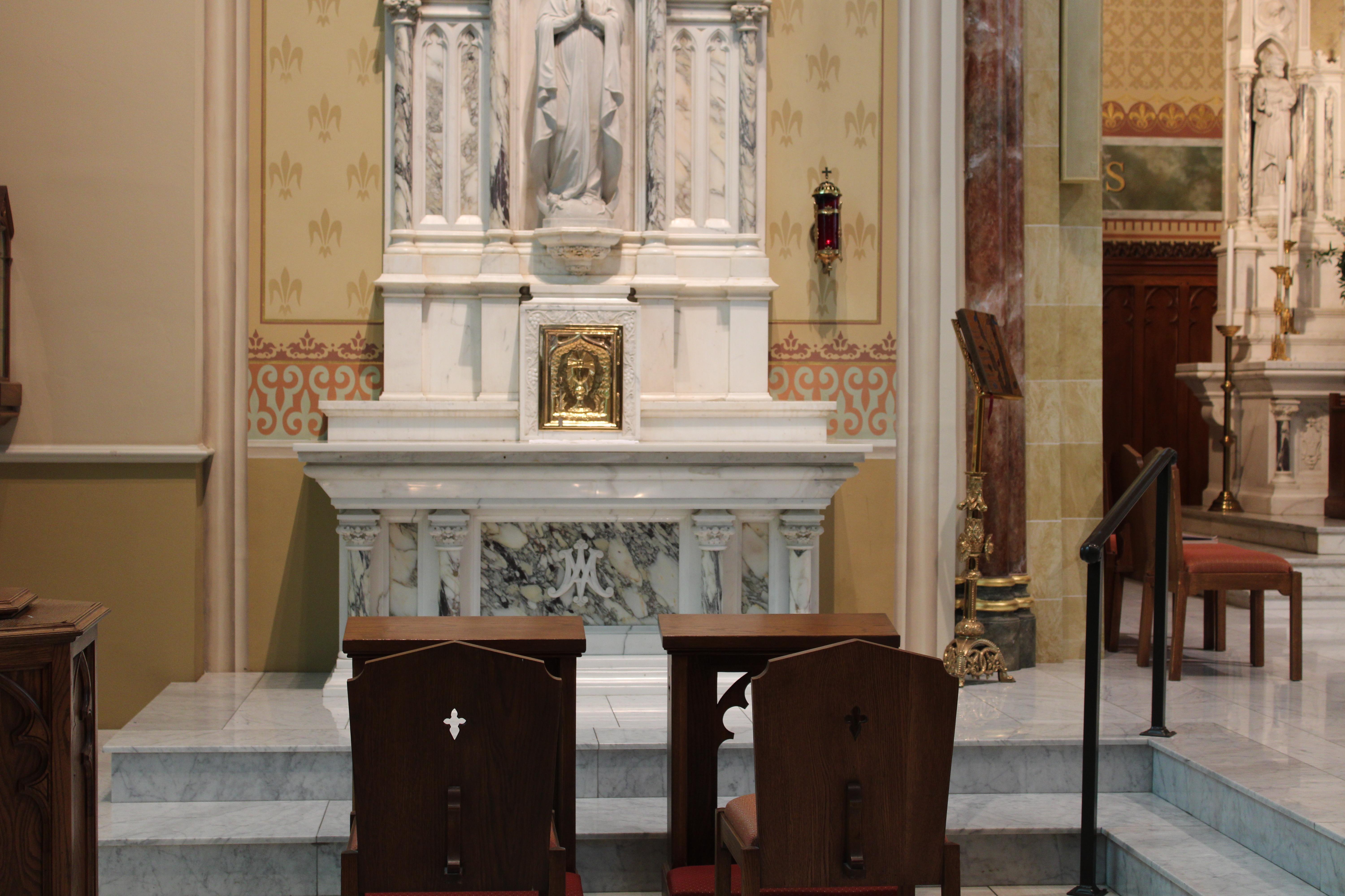 A gold, rectangle container, or tabernacle, is seen in a cathedral.