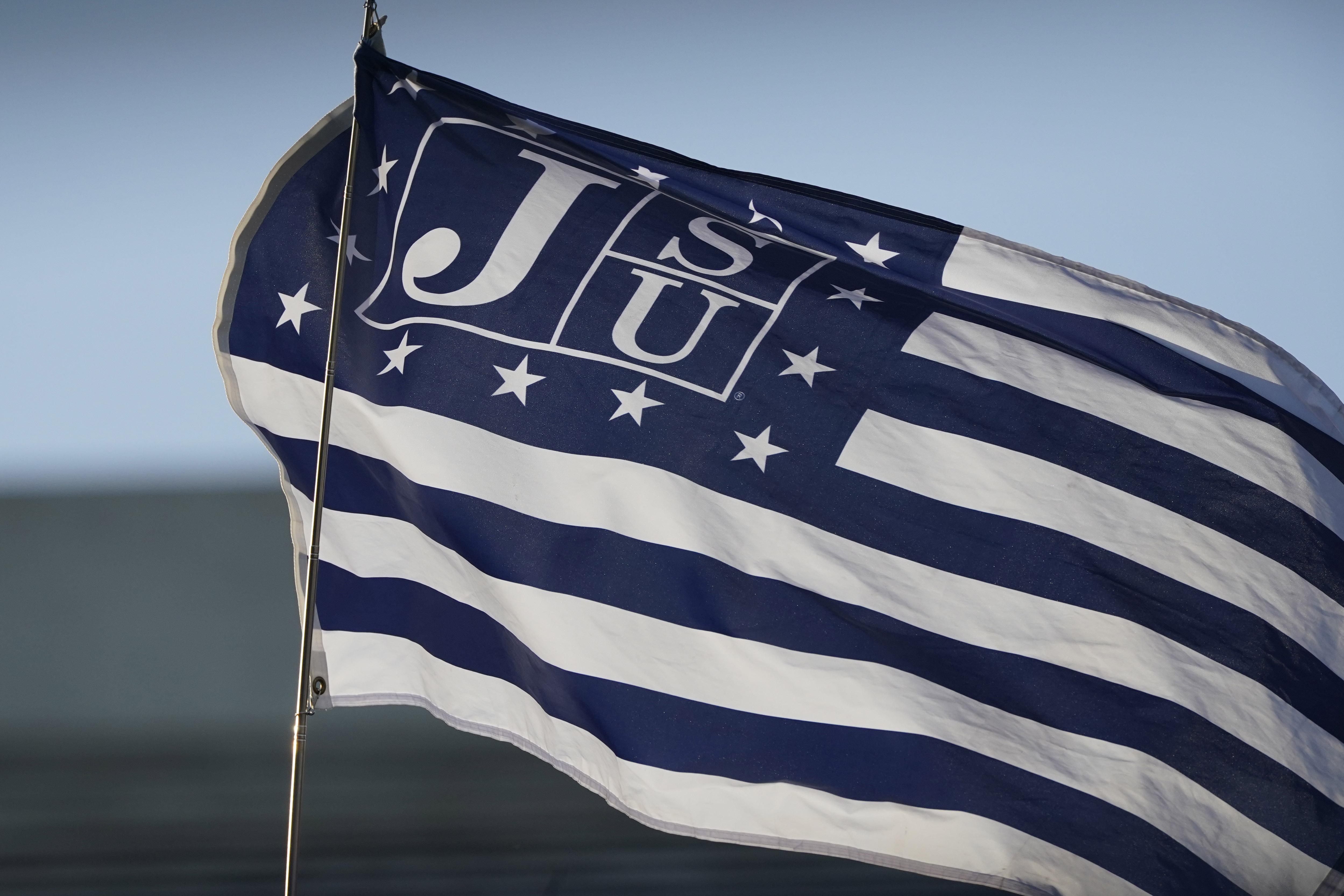 A blue and white Jackson State University flag waves in the air.
