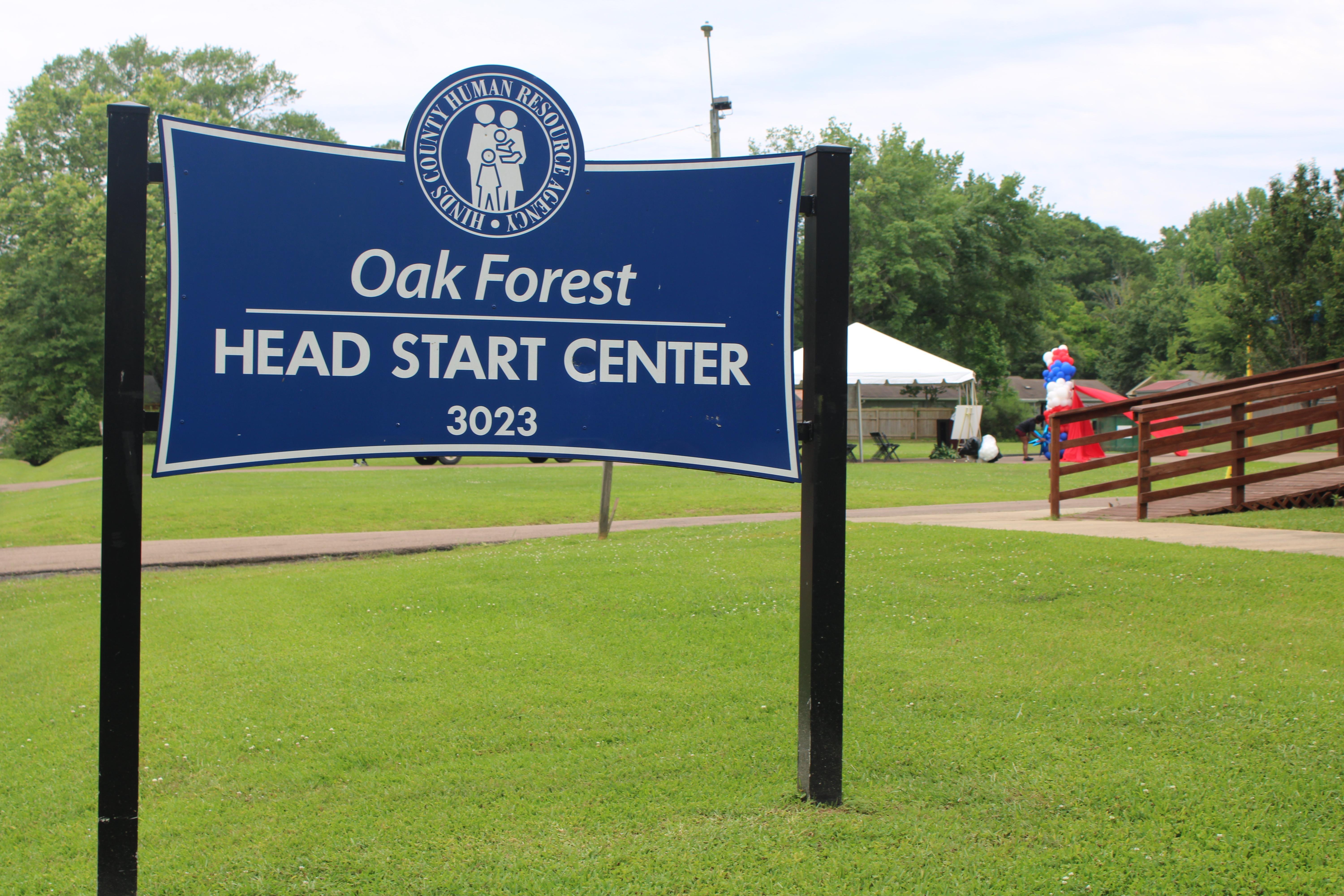 A sign reading the Oak Forest Head Start Center sits in front of a tent and balloons.