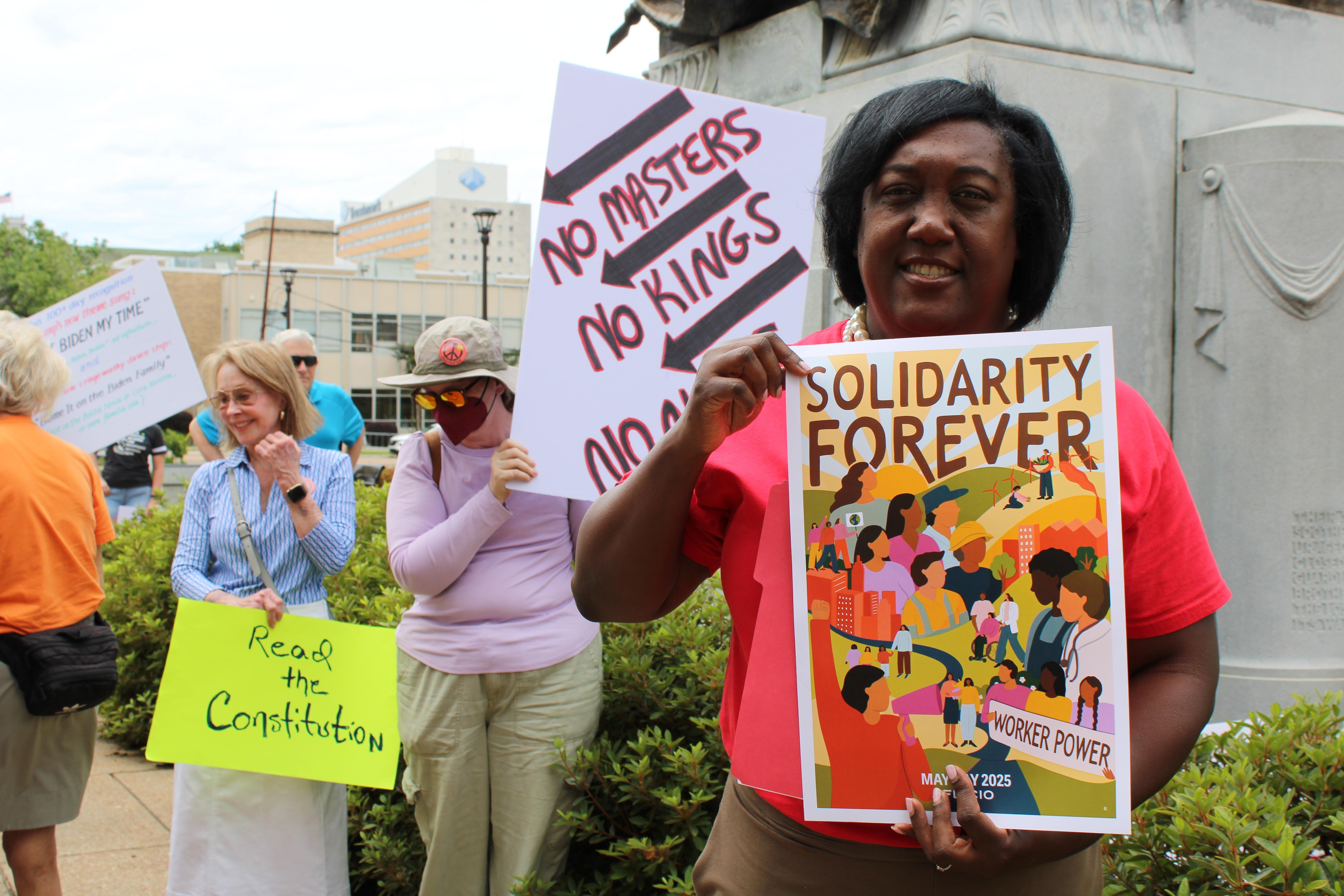 A woman holds a sign advocating for the rights of workers.