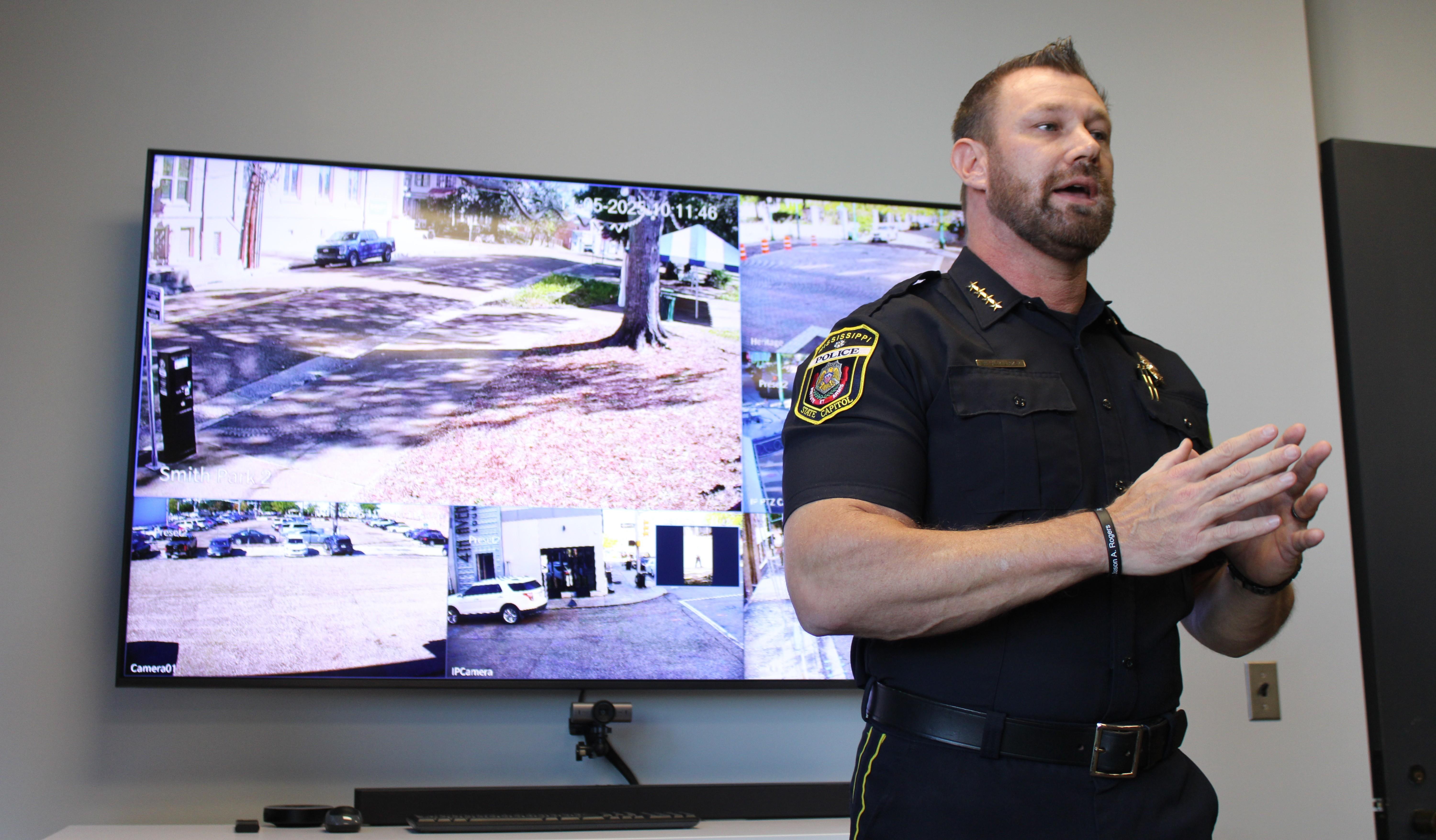 Capitol Police Chief Bo Luckey speaks in front of a television featuring live feeds from the new cameras.