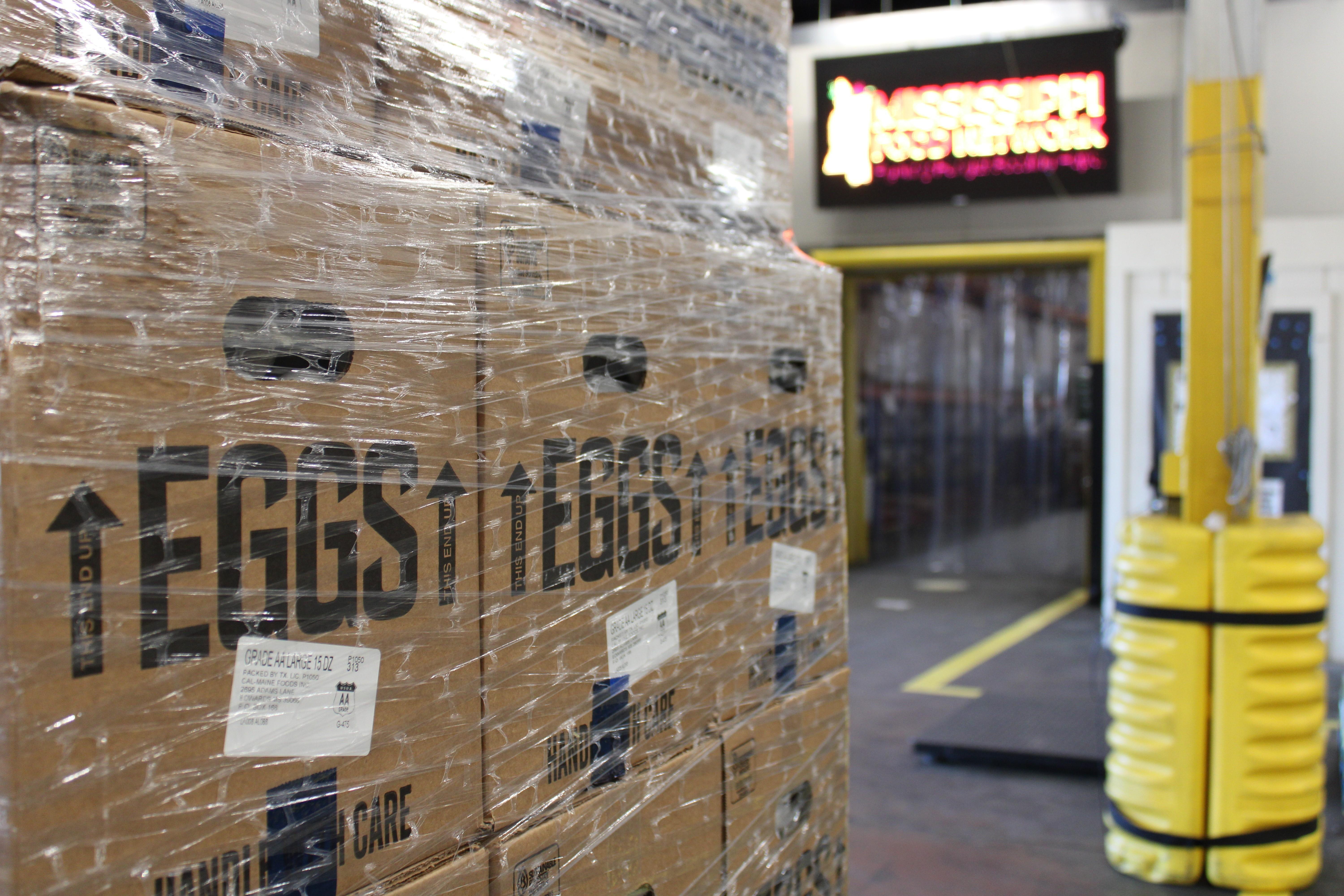 Cartons of eggs are seen, wrapped tightly in plastic, ready to be transported.