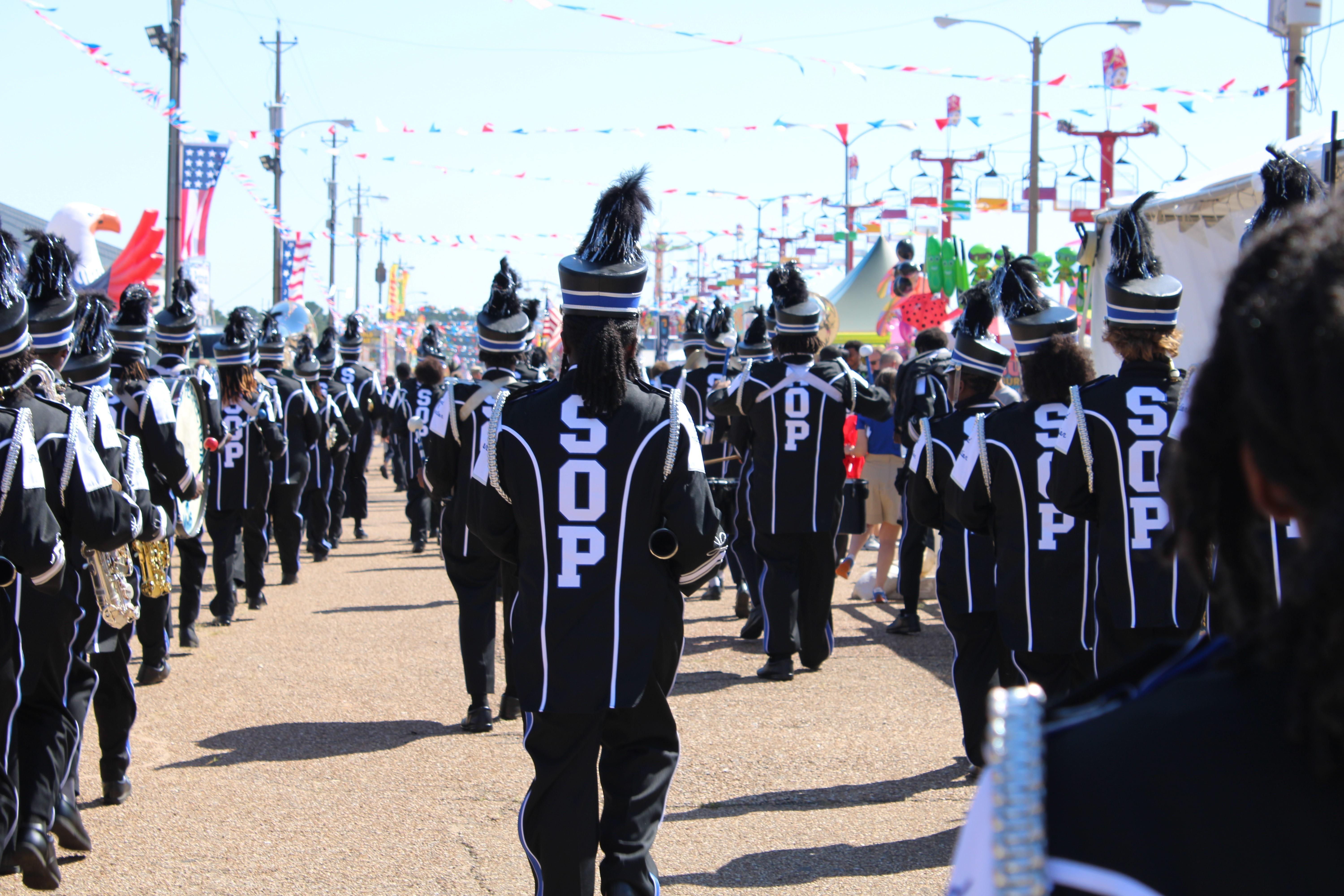 A high school band marches in full regalia.