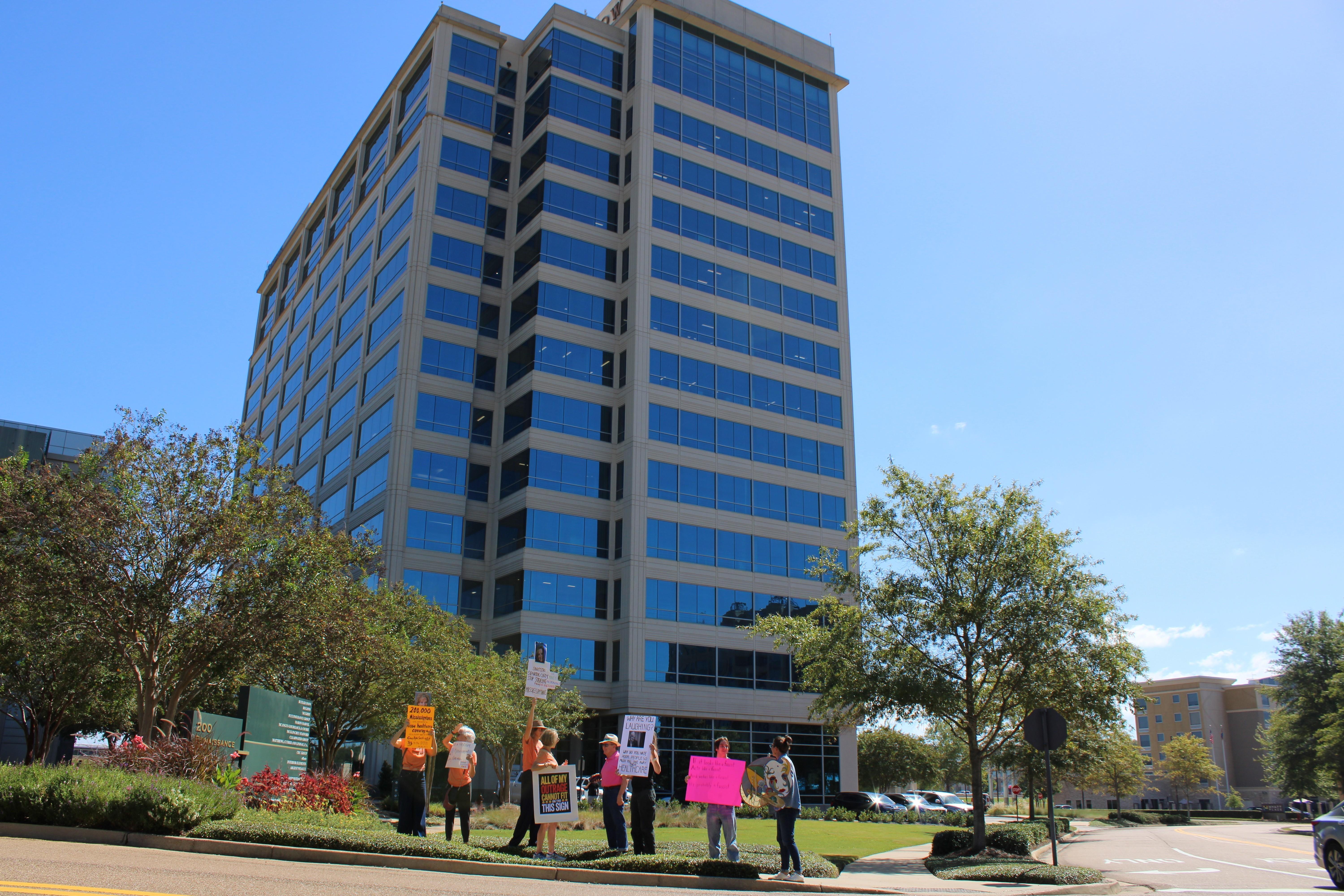 Protesters demonstrate in front of an office building.