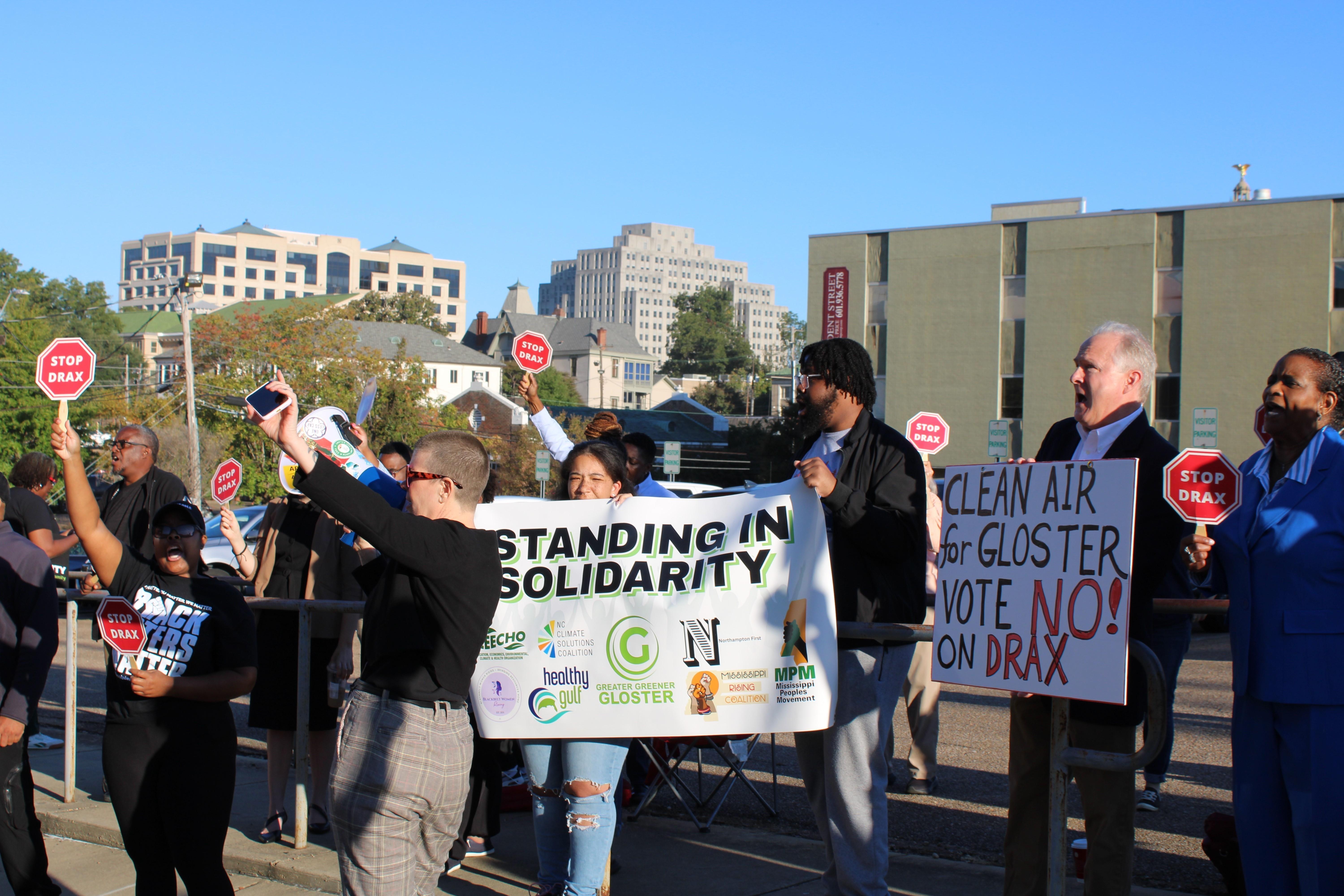 Protesters rally with signs and a bullhorn