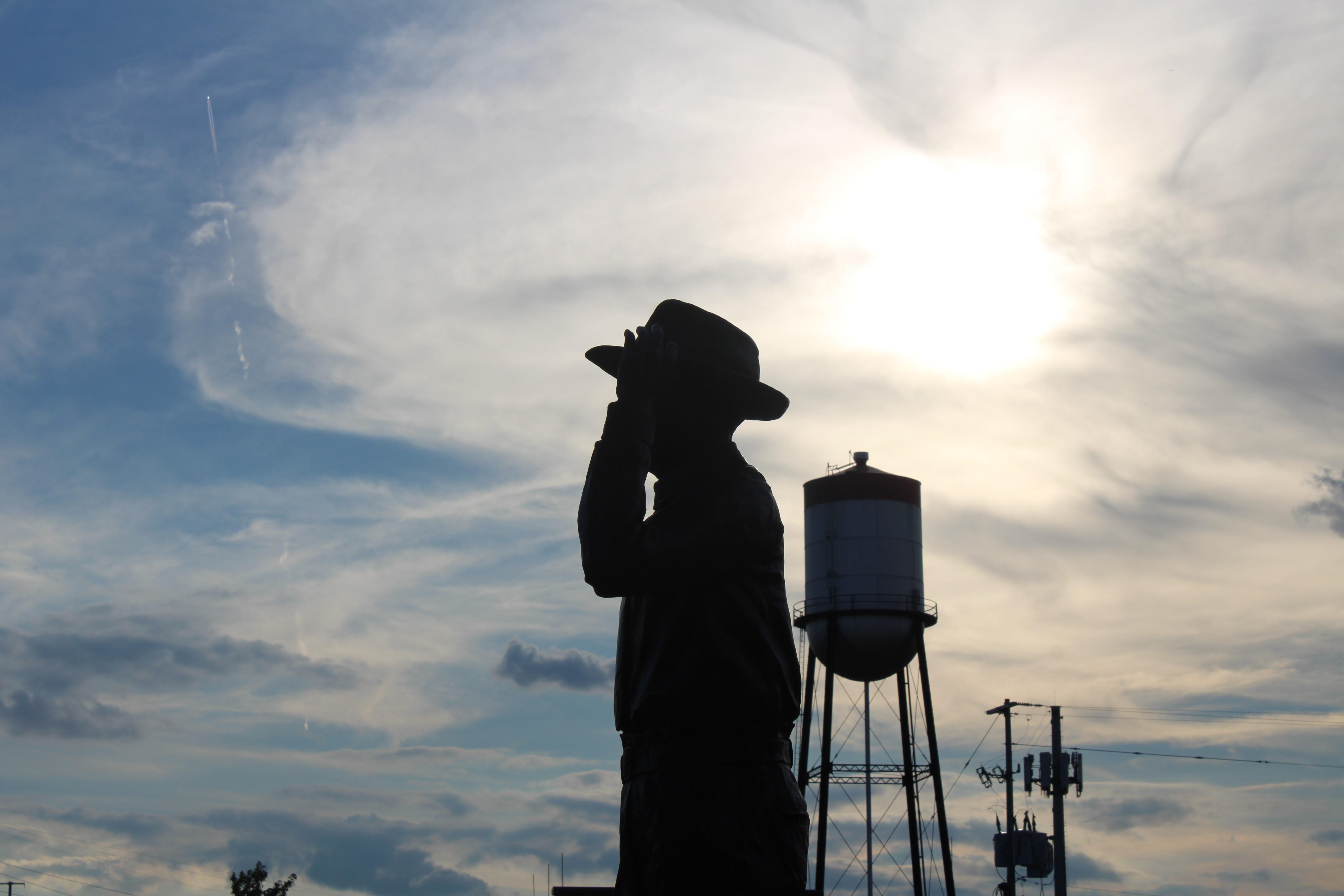 A statue of Emmett Till is seen in front of a sky backdrop.