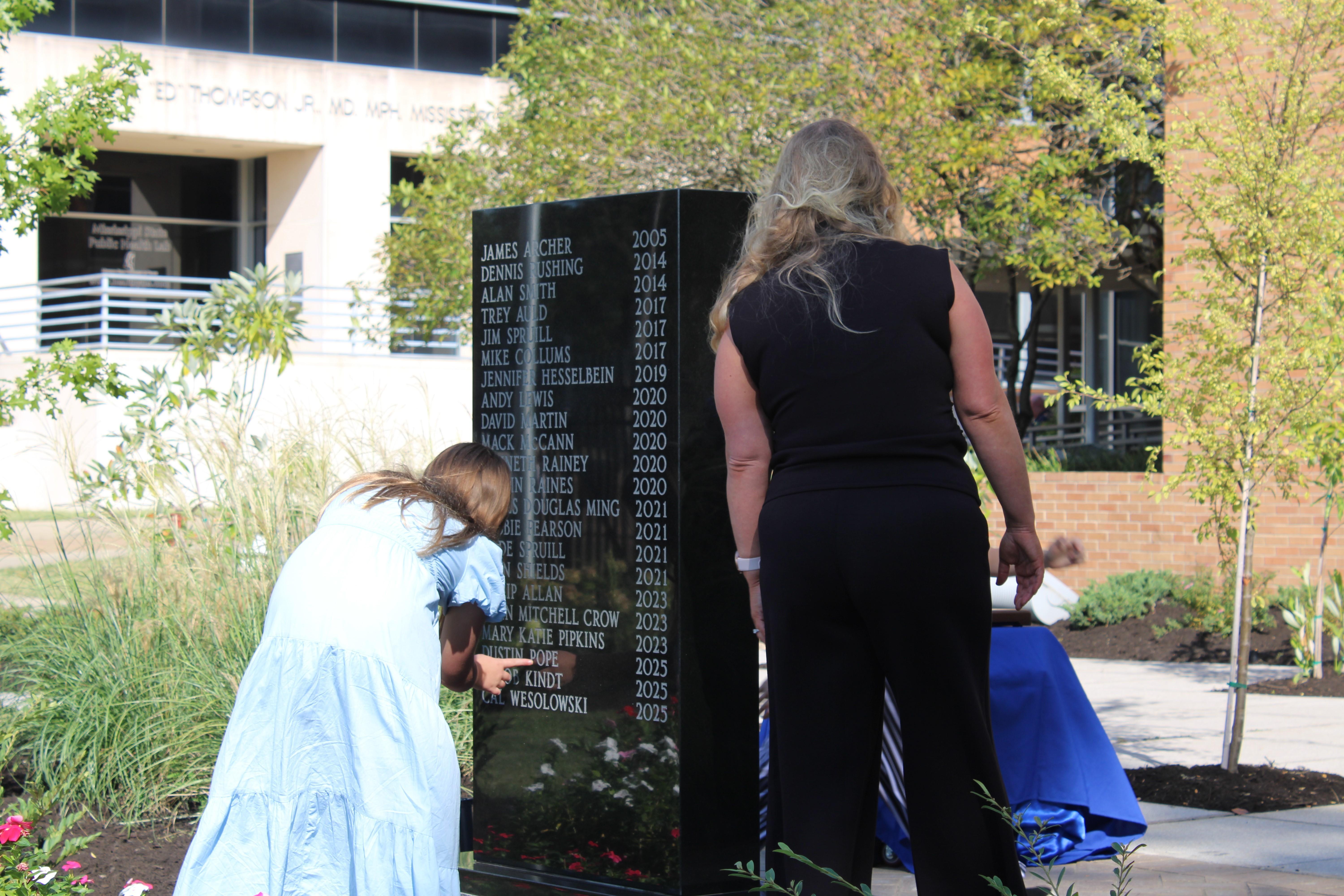 Family members of a fallen EMS professional read the name of their loved one on the EMS memorial in Jackson.