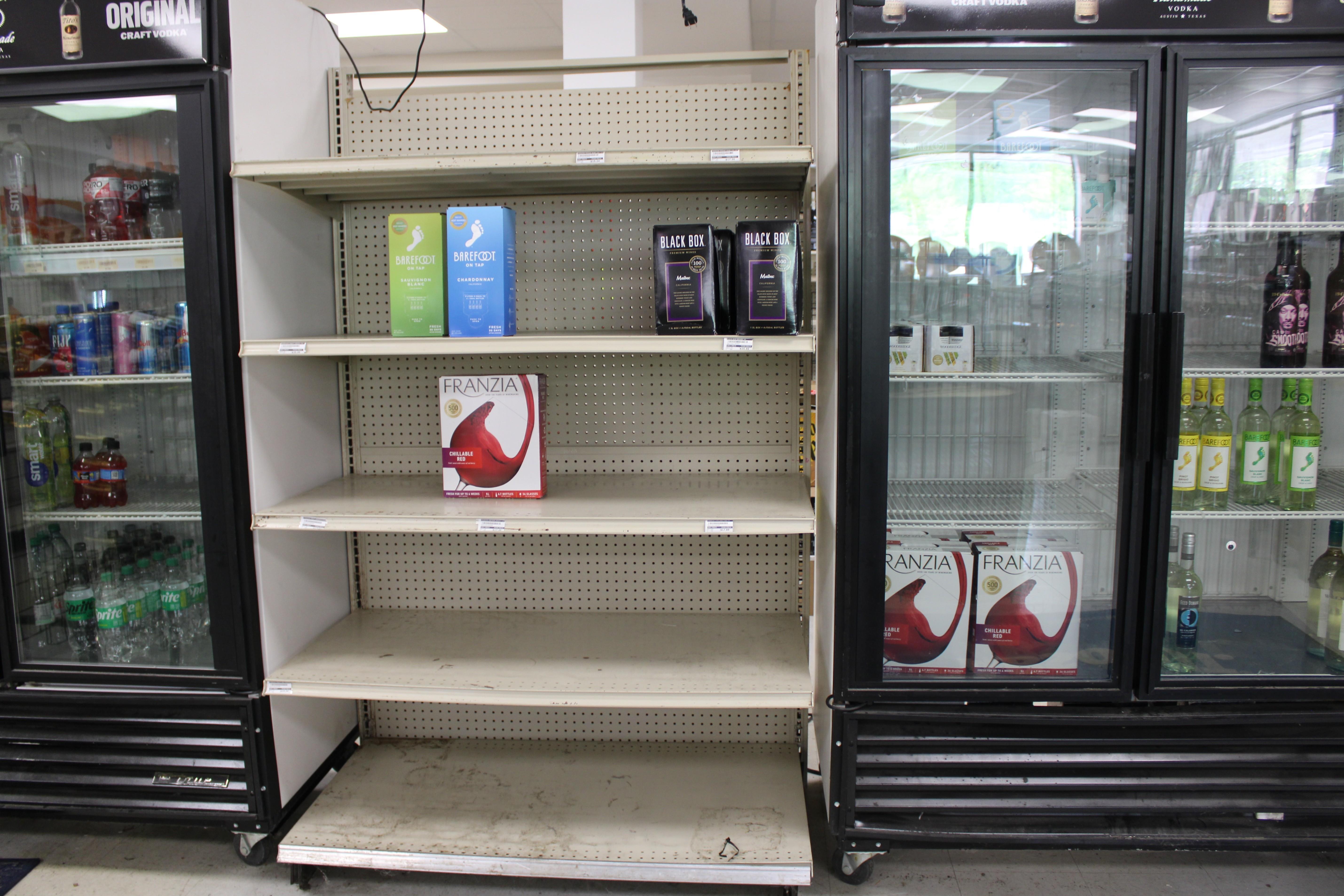 Nearly empty coolers and a few boxed wines are part of the limited supply of what's on hand in Arrow Wine and Spirits.