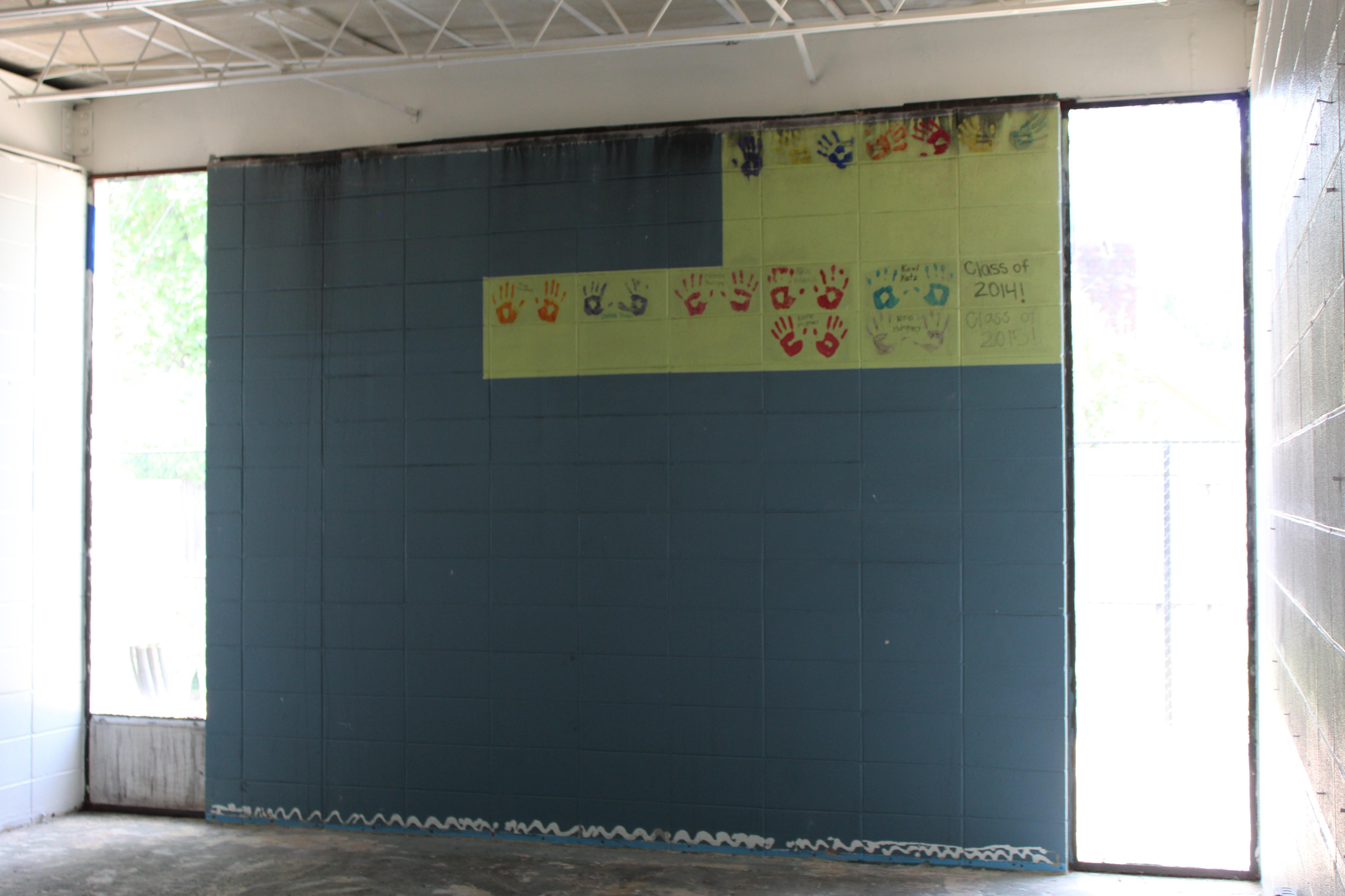 One room featured handprints imprinted on lime green paint, souvenirs from different graduating classes. Soot seeps down from the ceiling.