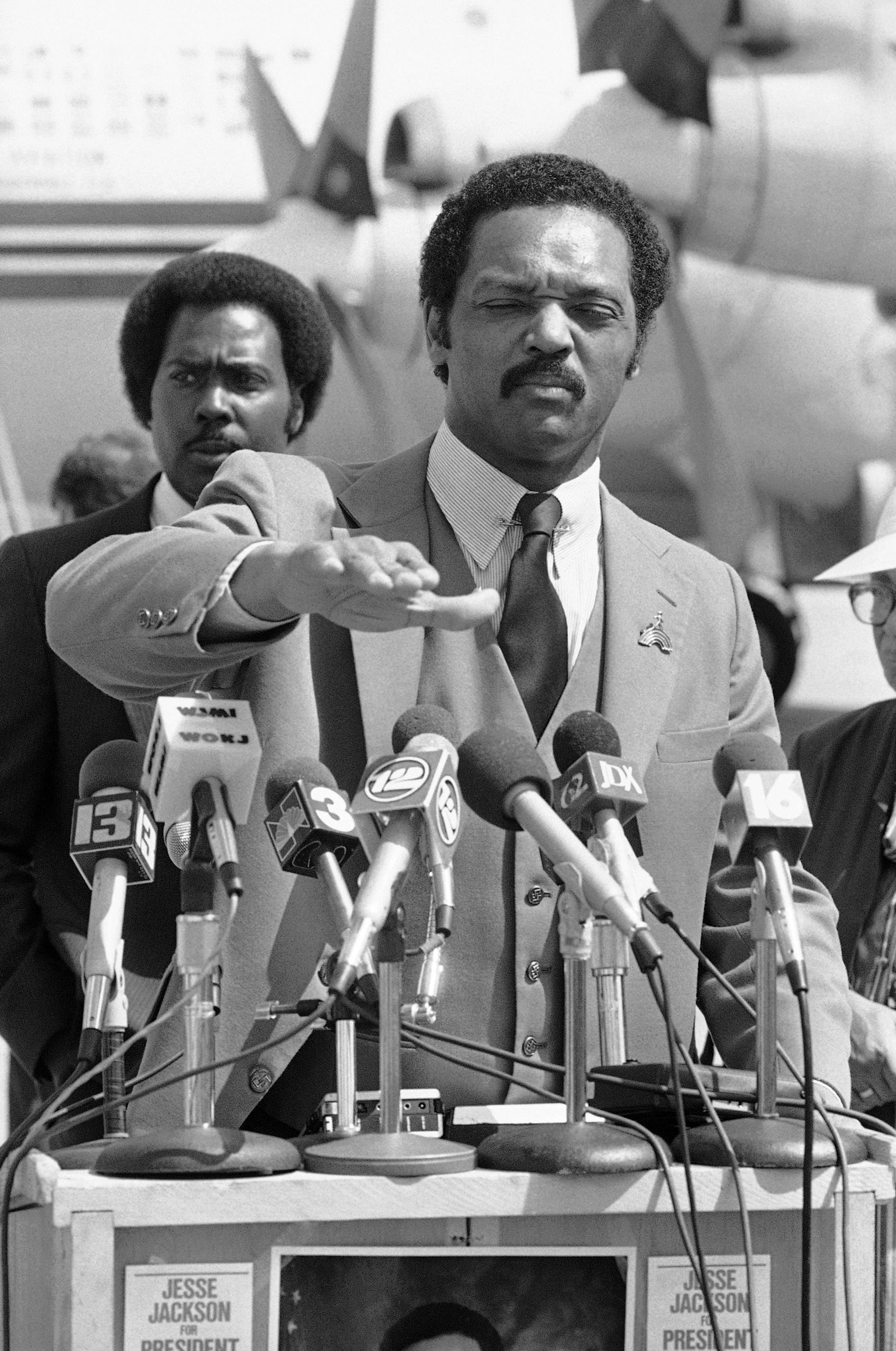 The Rev. Jesse Jackson speaks to the press in Jackson, Mississippi, Wednesday, March 15, 1984, while campaigning for the Democratic presidential nomination. Standing behind Jackson is Evan Doss of Port Gibson who was running for the U.S. House of Representatives.
