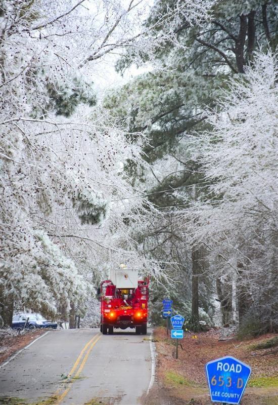 Emergency vehicle on Lee County road amid icy conditions caused by Winter Storm Fern.