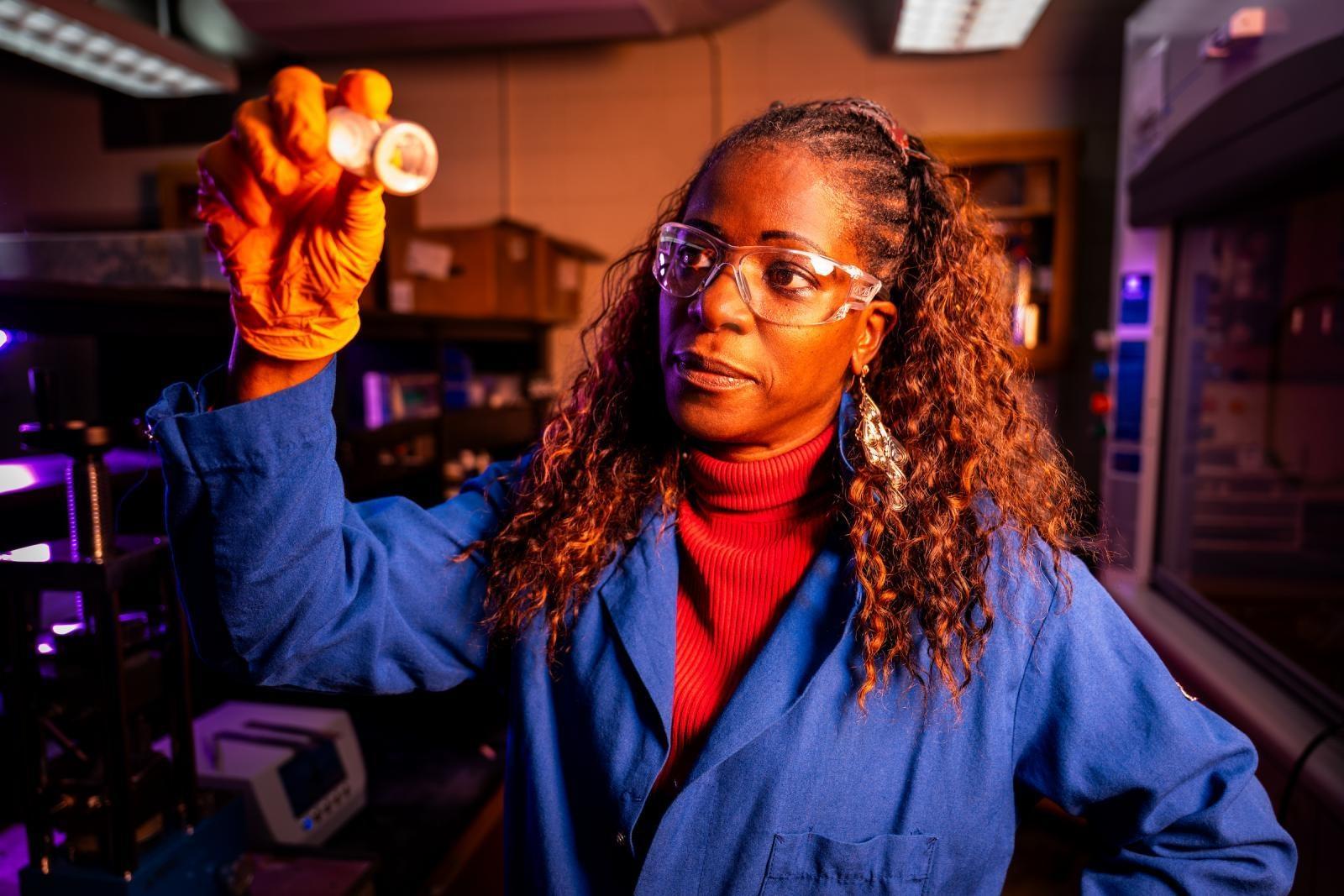 Mississippi State chemist Colleen Scott is the recipient of the Bayh-Dole Coalition's 2026 American Innovator Award for her award-winning technology that targets cancer cells. She's seen here looking at a vial wearing lab gear.