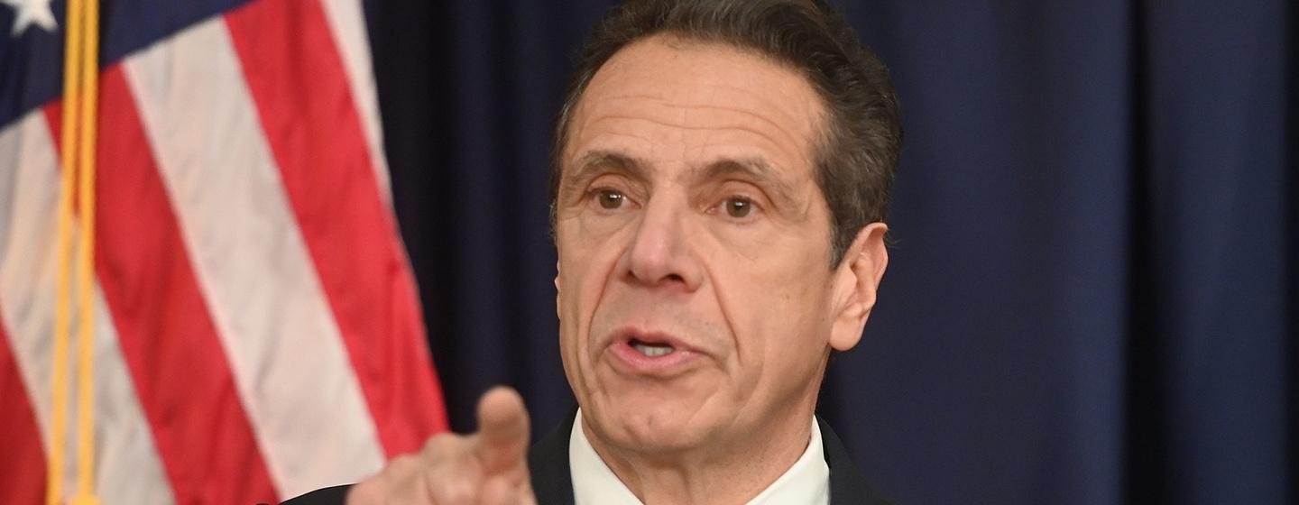 Close up image of Governor Andrew Cuomo with an American flag in the background