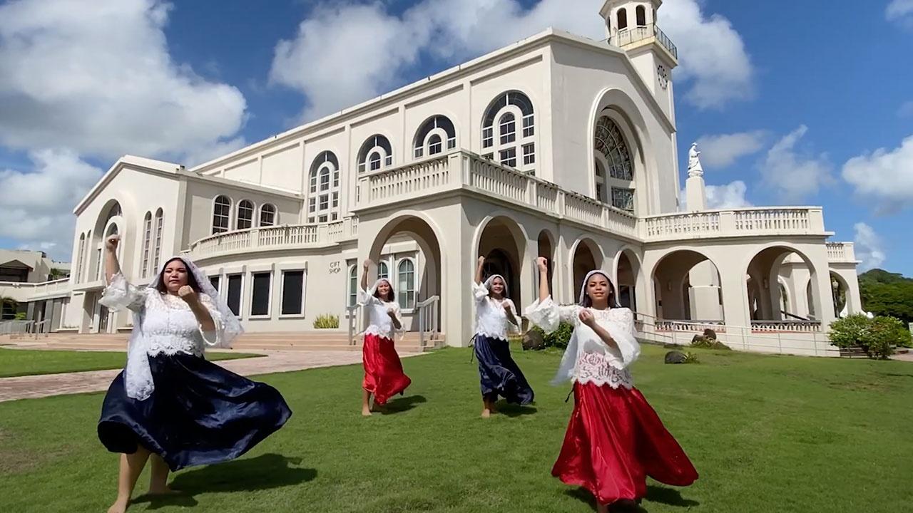 Four female traditional dancers perform on the lawn of the Dulce Nombre de Maria Cathedral Basilica on Guam