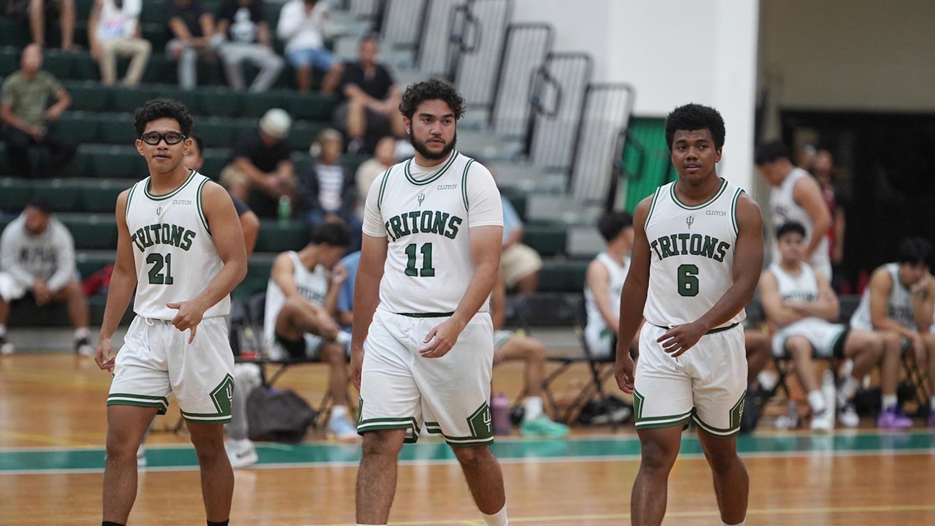 Three basketball players from the University of Guam as they walk across the court