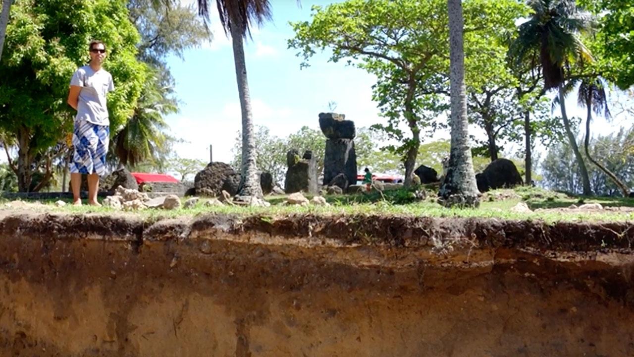 Show host Dr. Mike Carson stands above an excavation dig site with original CHamoru latte stones