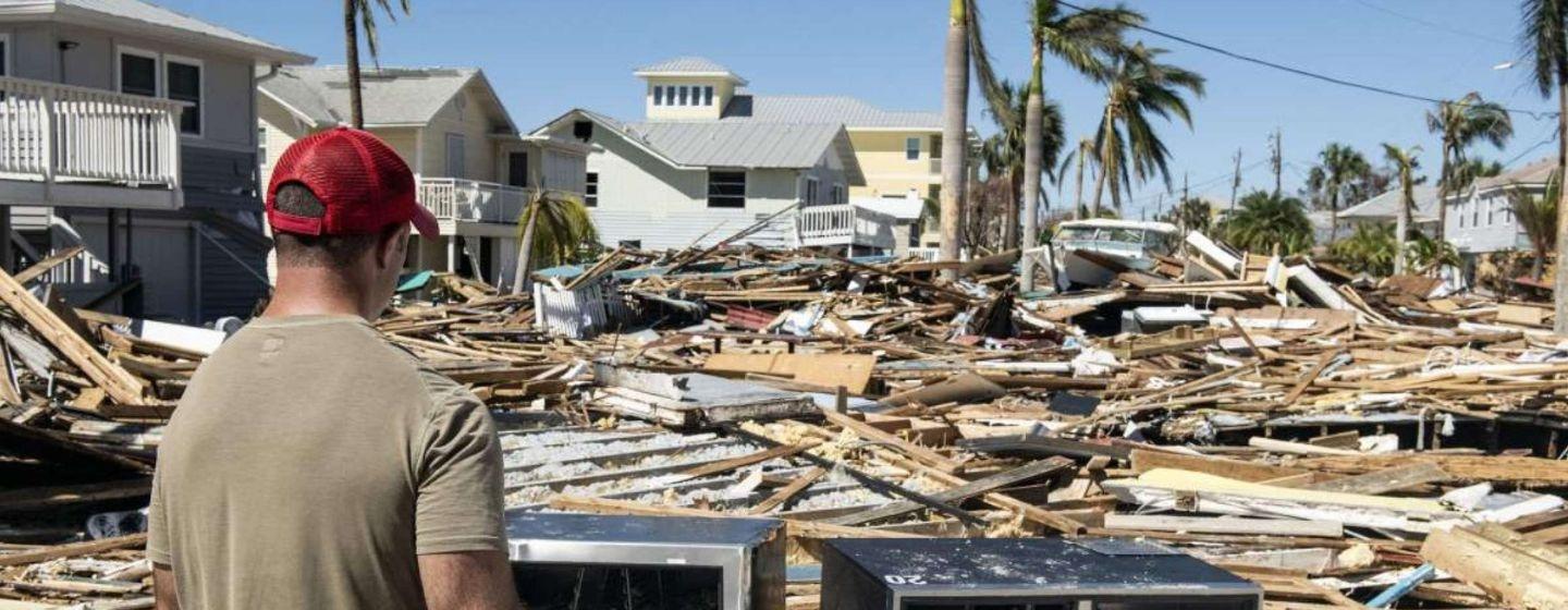 A man staring at the extreme damage caused by hurricane Ian in Florida.