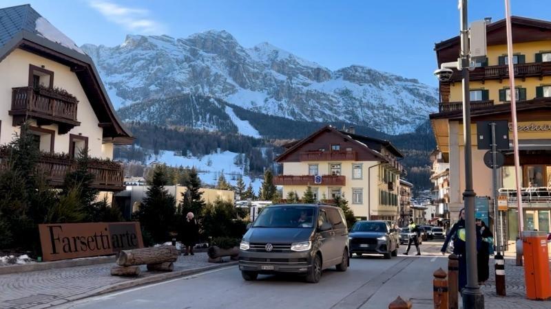 Spectators walk through a Winter Games venue in Bormio, where the Milan–Cortina Olympics rely on existing mountain towns and infrastructure to reduce new construction and limit environmental impact.