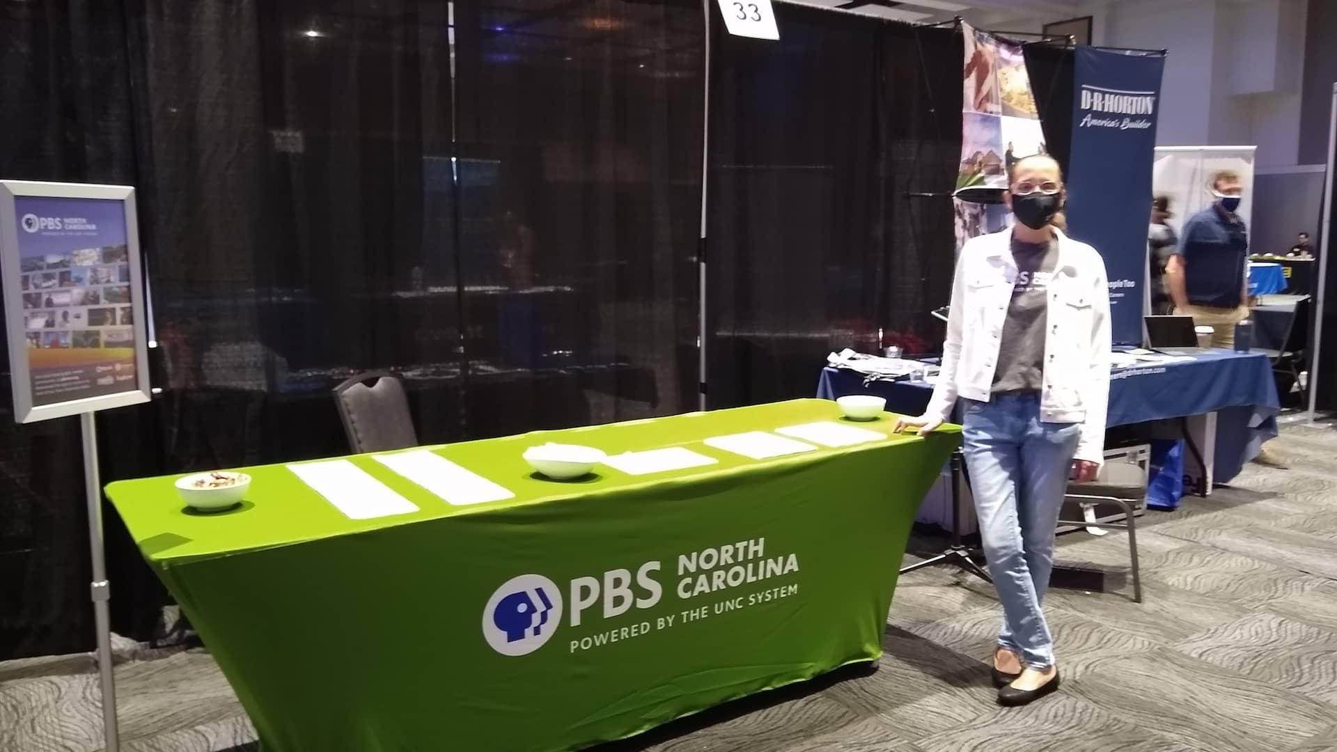 Judy Munson poses in front of the PBS North Carolina table at a career fair