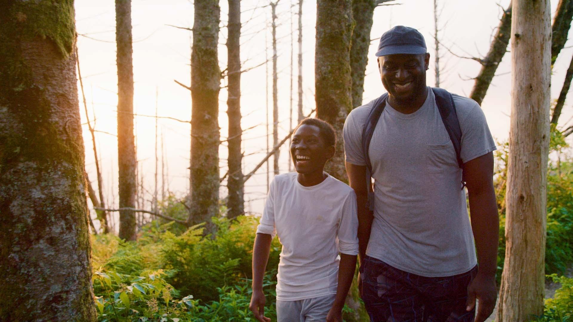 A father and son hike through the woods in a North Carolina state park