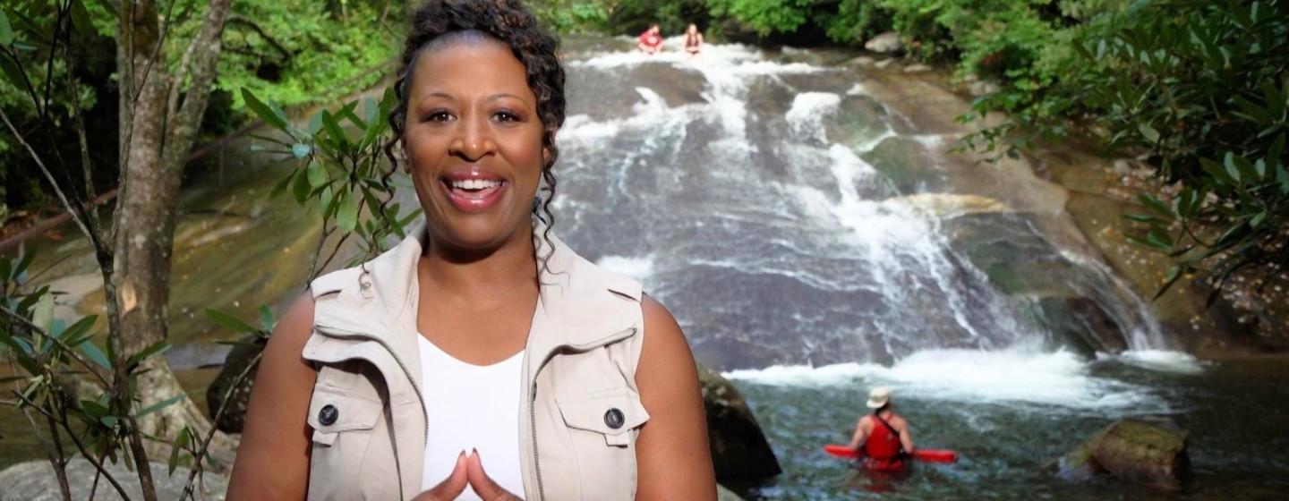 Host Deborah Holt Noel in front of a waterfall in Brevard, NC.