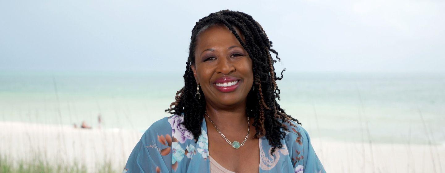 Deborah Holt Noel, host of NC Weekend in front of a beach on Ocracoke.