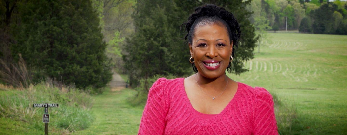 Deborah Holt Noel, host of NC Weekend in front of a trail on Blackwood Farm Park called Mary's Trail.