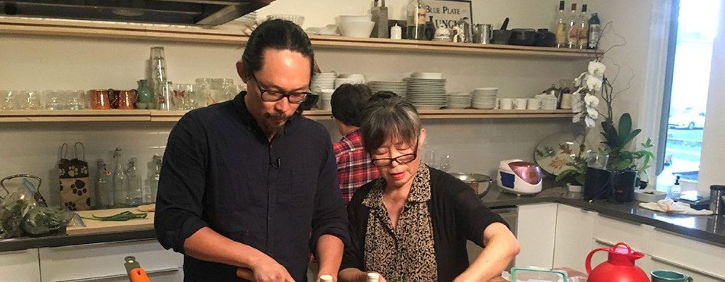 Joe Kwon and his mother stand in a kitchen, cooking together.
