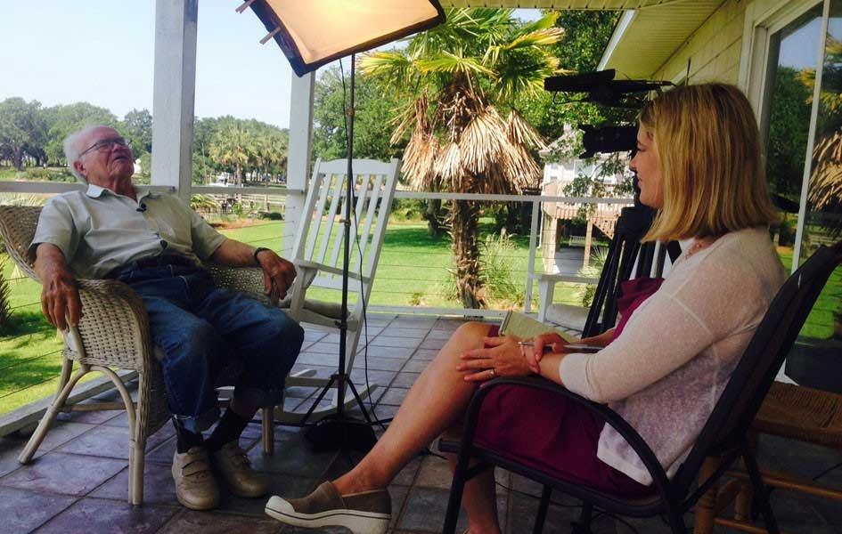 Heather Burgiss and Frank Nesmith sitting on a covered porch talking
