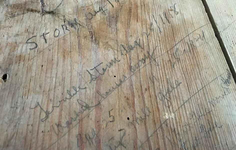 piece of old and worn wood with writing on it
