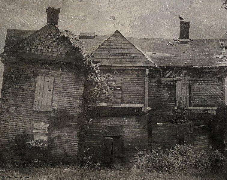 Black and white photo of abandoned house with vegetation growing within it
