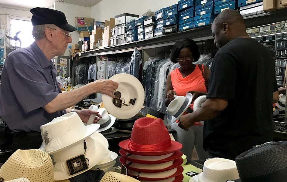 John Mitchell handing customer and his wife a hat