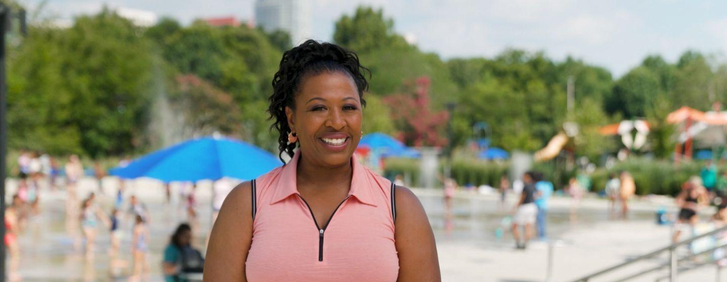 Deborah Holt Noel smiles for the camera outside on a warm sunny day.