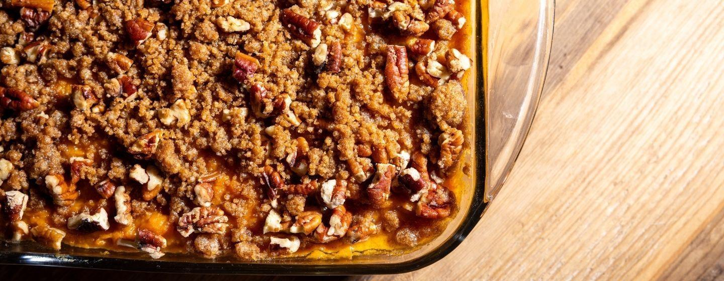 Sweet potato casserole with pecan crumble in a glass baking pan.