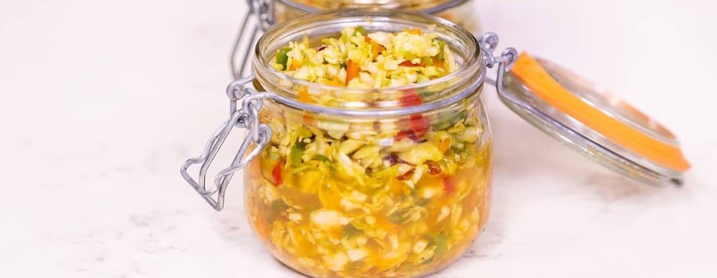 Chow Chow Slaw in small glass jar with lid popped open