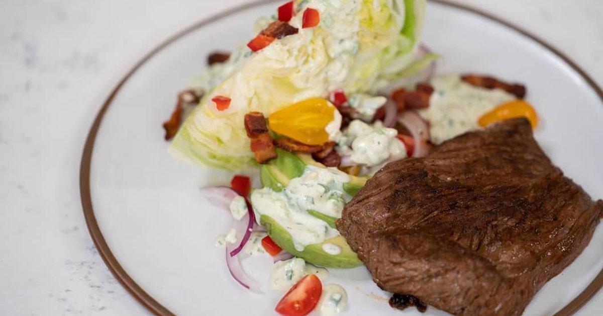 Plate with buttermilk brined steak and a salad.