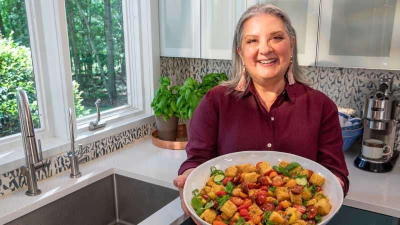 Sheri Castles presents a dish of tomato panzanella in a bright kitchen