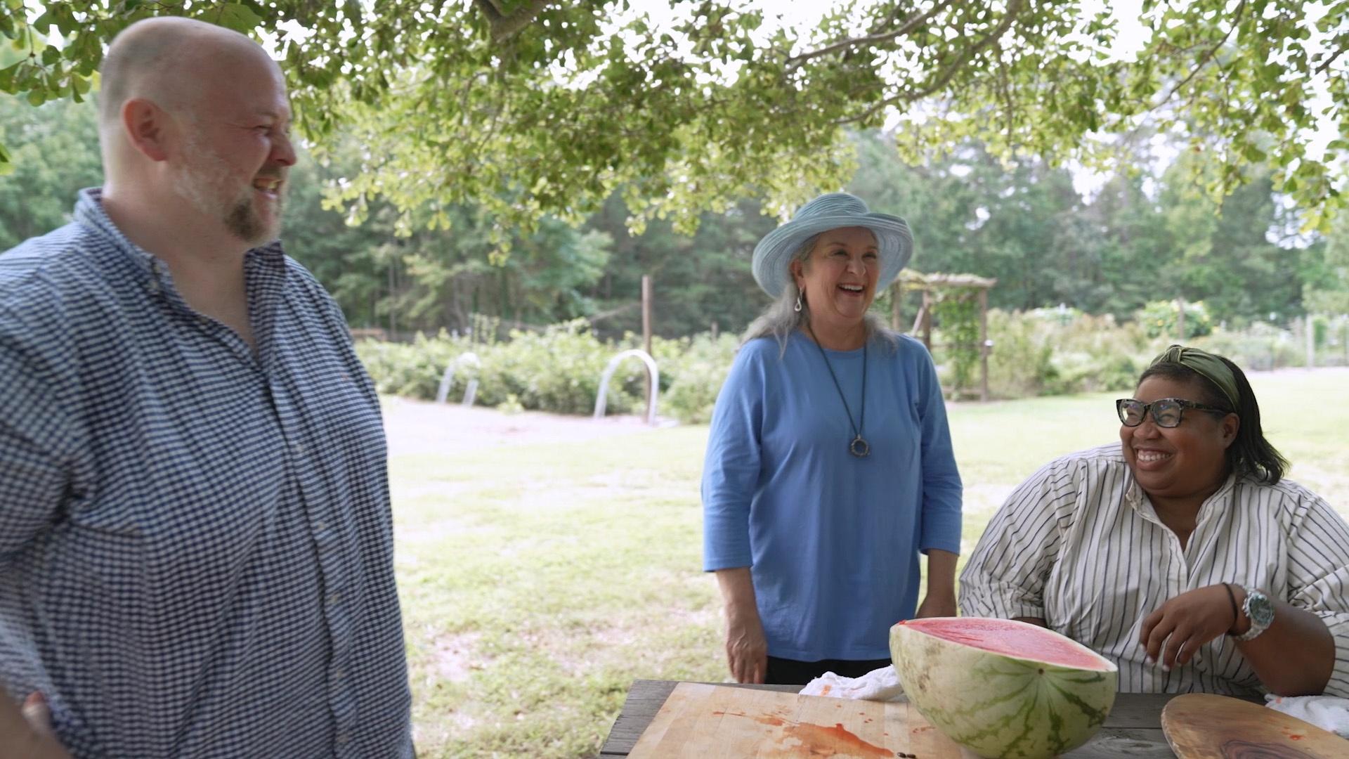 Sheri Castle between Deb Freeman and Joshua "Fitz" Fitzwater as they smile in laughter.