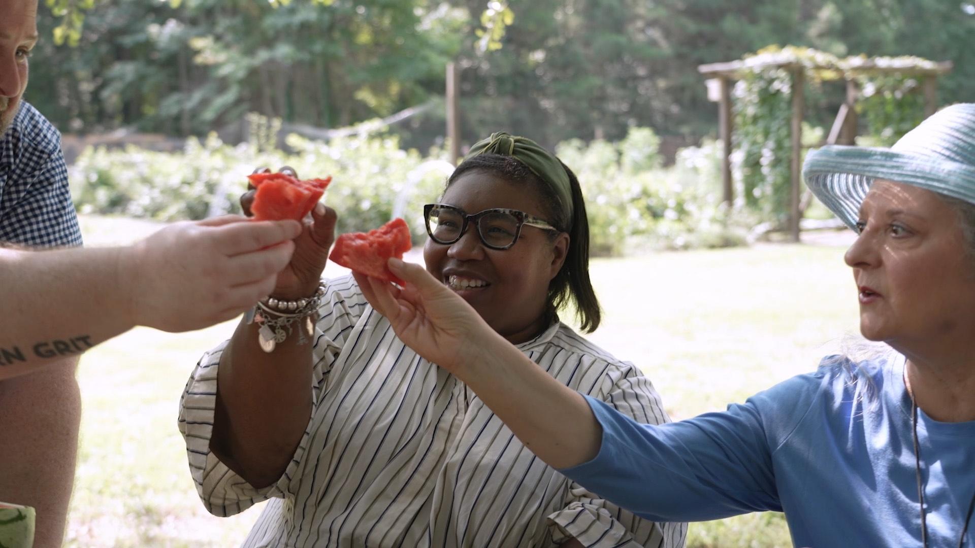 Fitz, Deb and Sheri "clinking" their watermelon chunk before eating them.