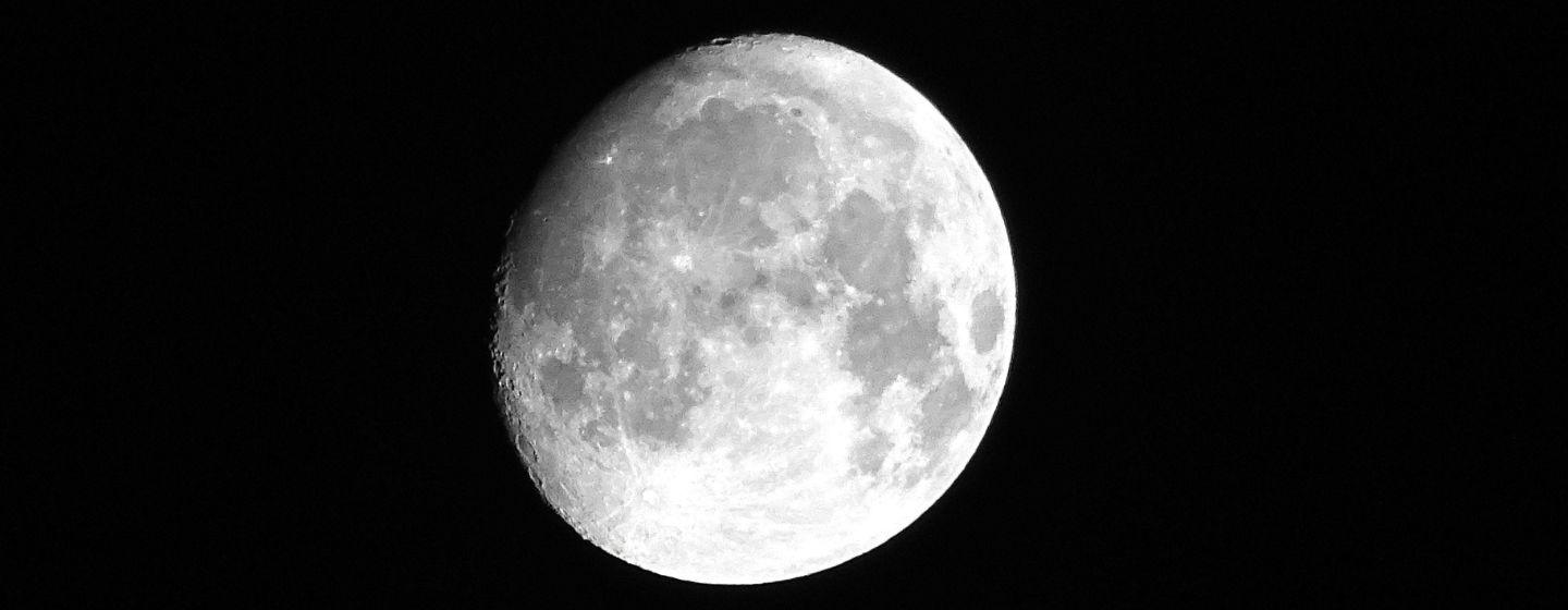 The moon with a shadow over the top left side.