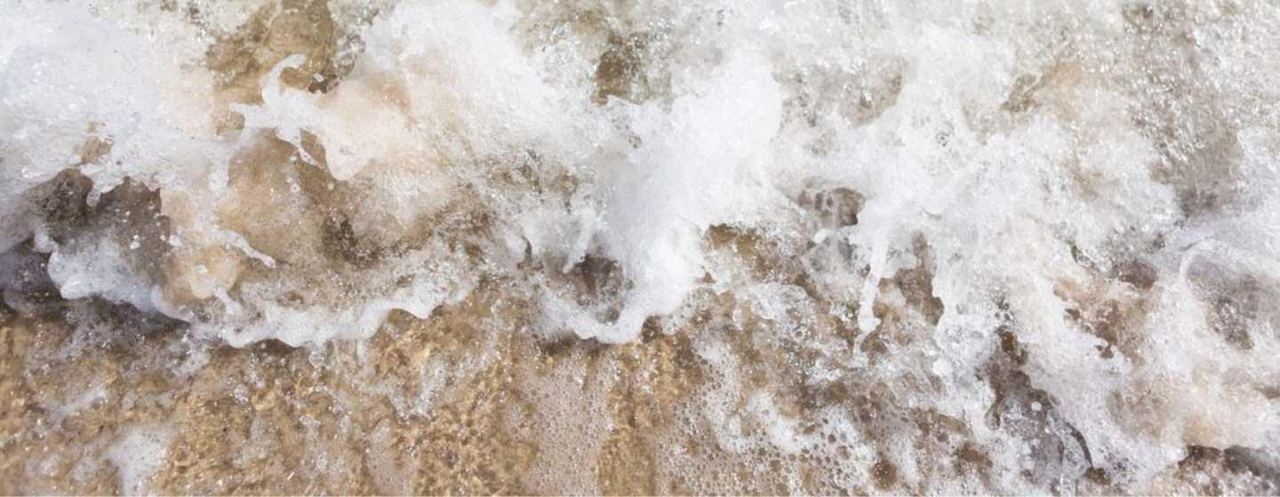 closeup of waves crashing on the shore
