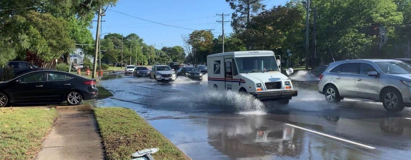 Cars driving through the heavily flooded street from rainwater