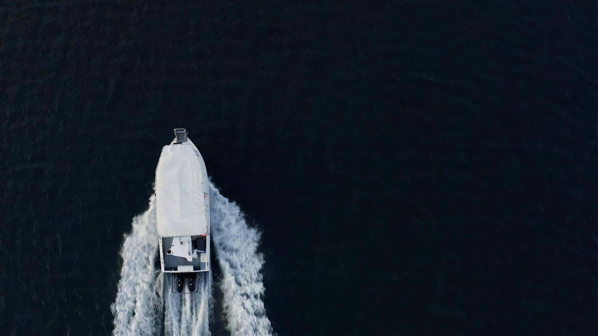 aerial shot of white boat on dark ocean water