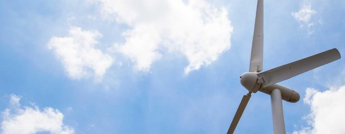 Closeup of a wind turbine against a blue sky