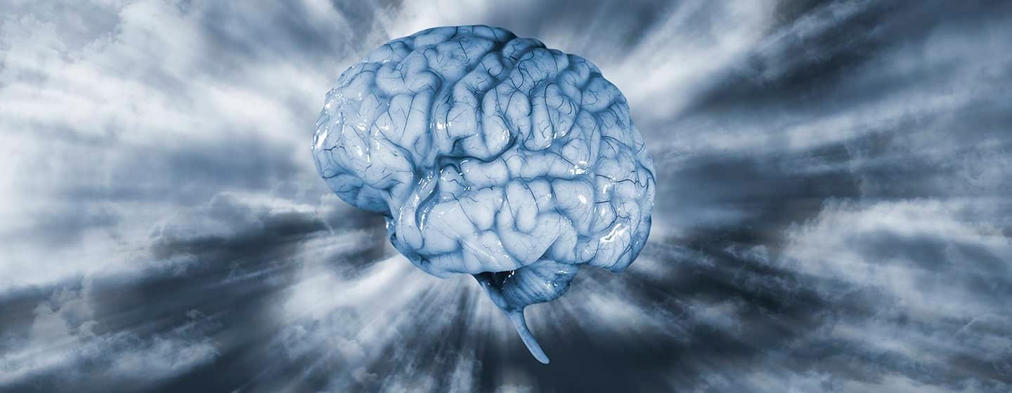 A realistic looking, slimy and vein covered brain in a blue tone, suspended in front of grey clouds with sunburst of light highlighting the brain.