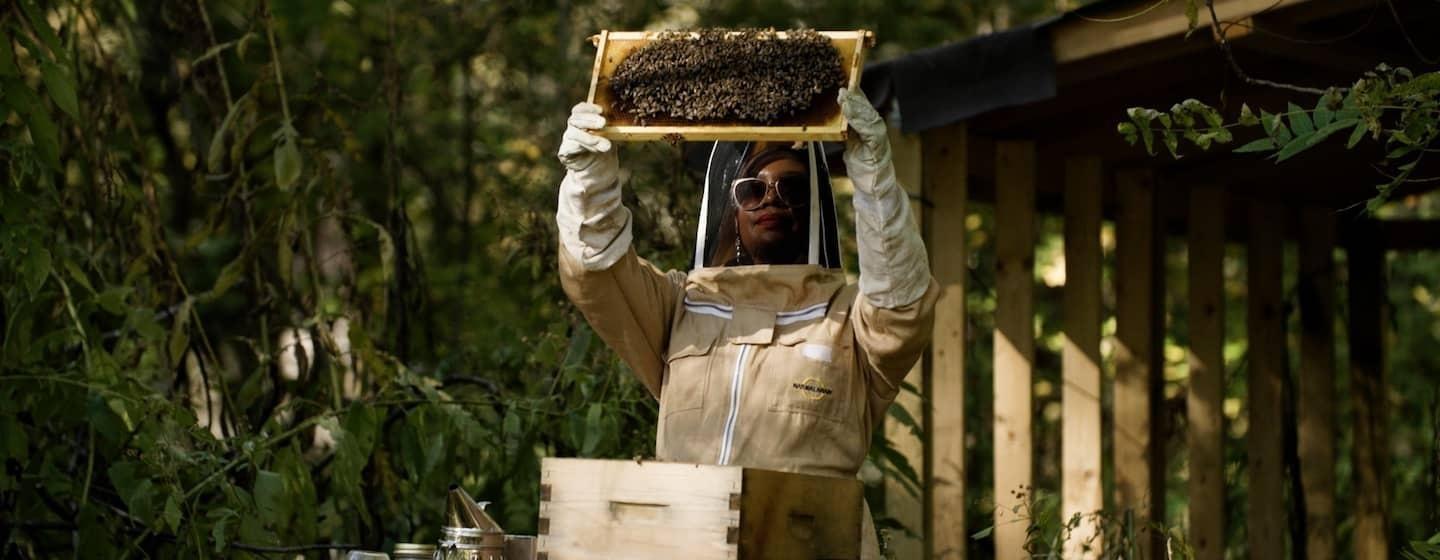 beekeeper samantha winship holding up colony of bees